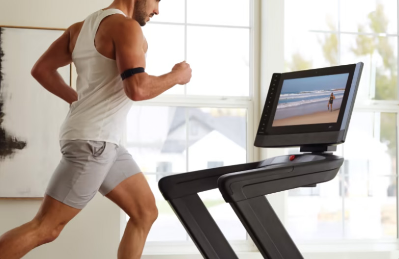 Woman running on NordicTrack Commercial 2450 treadmill in room in her house